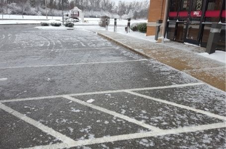 A large commercial parking lot that has been cleared of snow and ice in the winter.